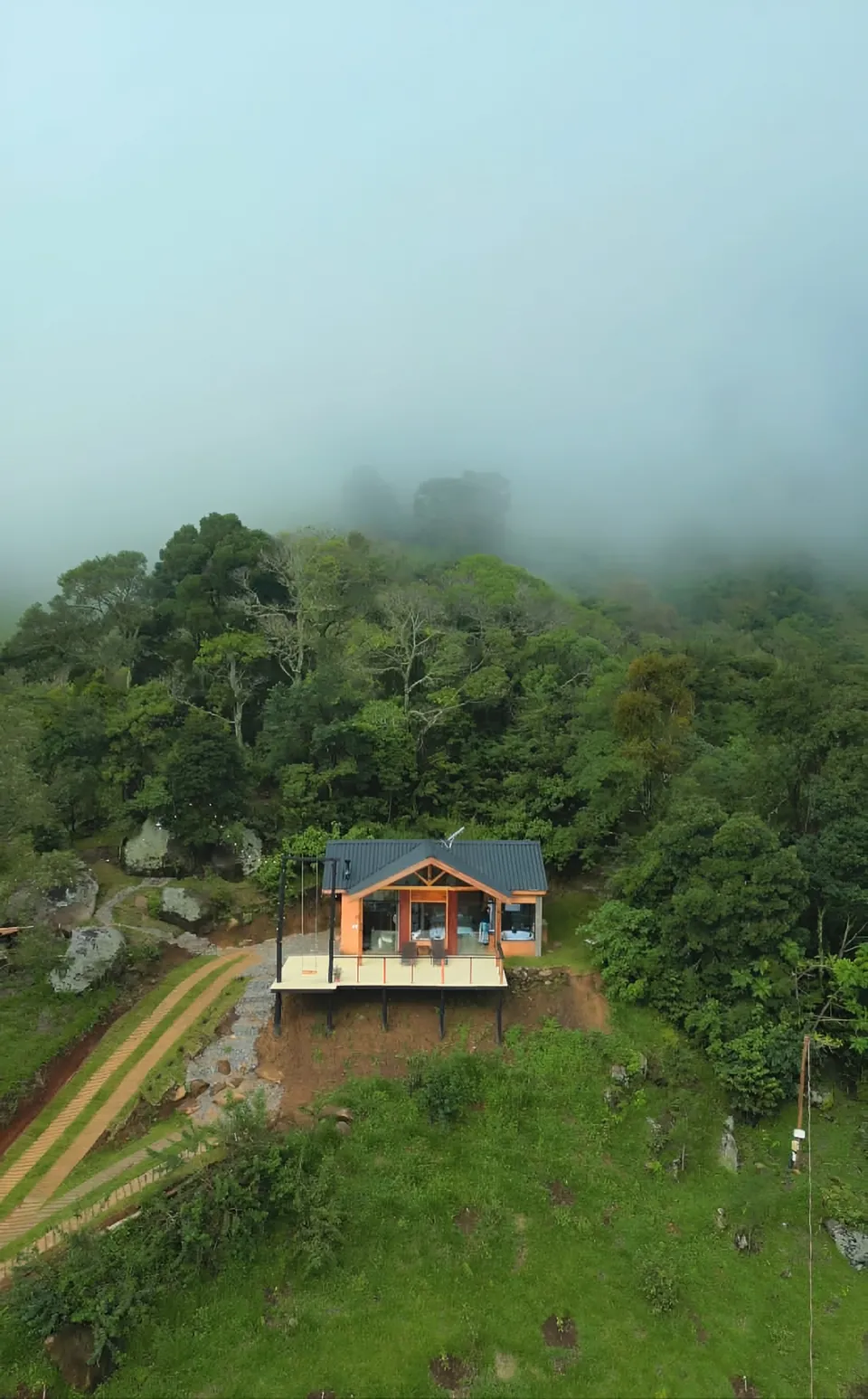 Vista aérea da Belvedere no meio da mata, com a neblina sobre o morro.