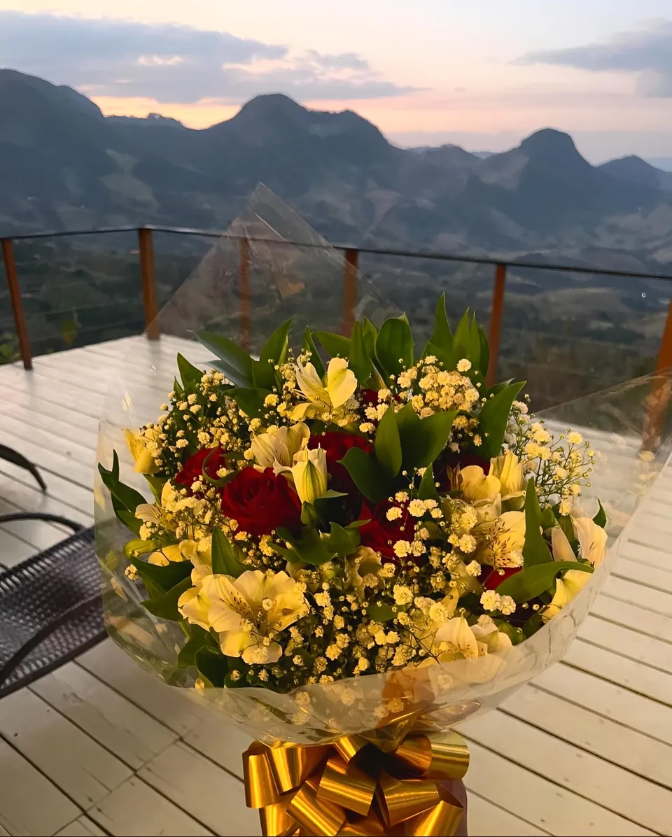 Buquê de flores no deck, com as montanhas ao entardecer.